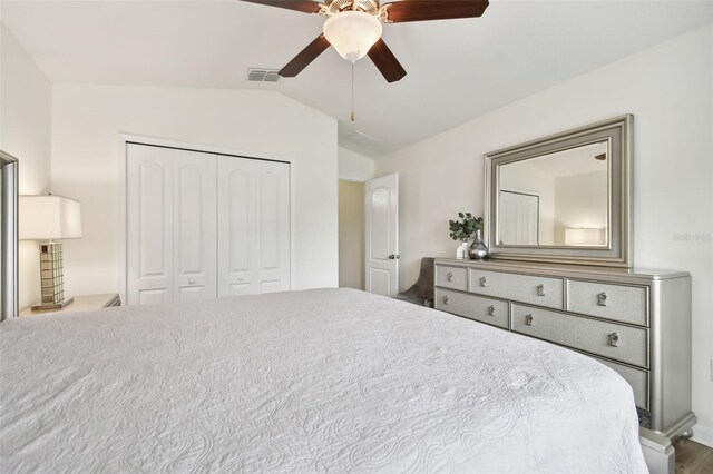 bedroom featuring lofted ceiling, ceiling fan, and a closet