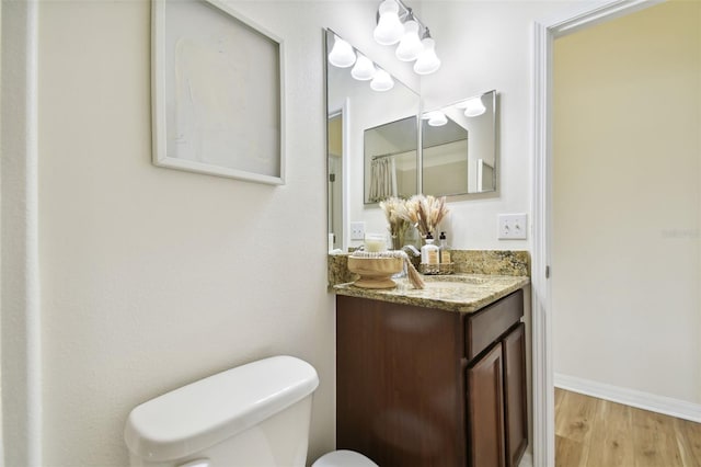 bathroom with hardwood / wood-style floors, vanity, and toilet