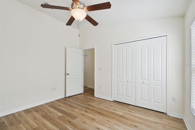 unfurnished bedroom featuring light wood-type flooring, ceiling fan, and a closet