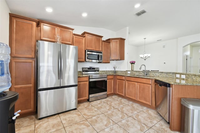 kitchen with light tile patterned flooring, appliances with stainless steel finishes, hanging light fixtures, sink, and vaulted ceiling