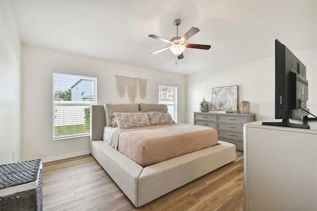 bedroom featuring light hardwood / wood-style floors, multiple windows, and ceiling fan