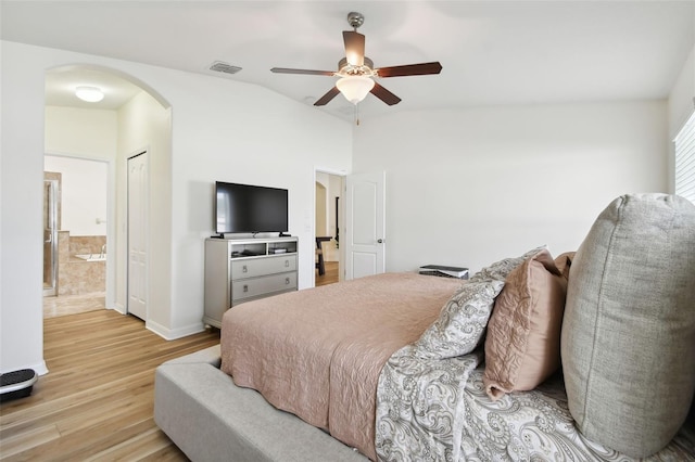 bedroom featuring ensuite bath, vaulted ceiling, ceiling fan, a closet, and light hardwood / wood-style flooring