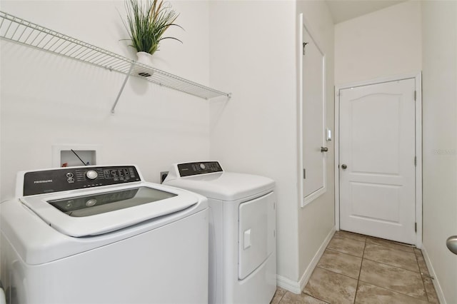 laundry area with light tile patterned floors and washer and dryer