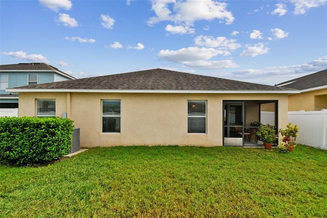 back of property with a lawn and a sunroom