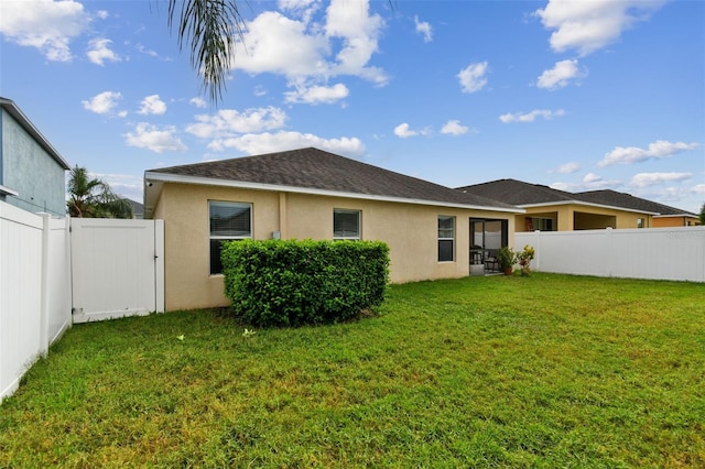 rear view of property featuring a lawn