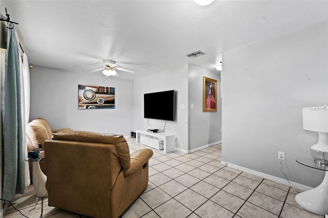 living room with a textured ceiling, ceiling fan, and light tile patterned floors