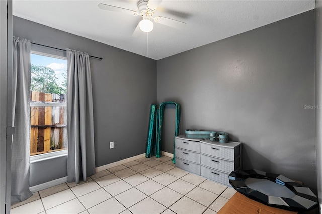 interior space featuring light tile patterned flooring, a textured ceiling, and ceiling fan