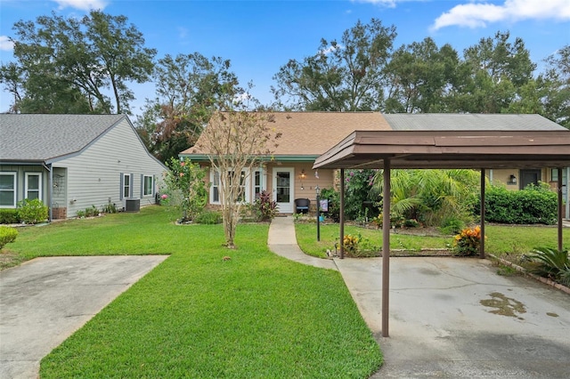 view of front of home featuring a front lawn, a carport, and central air condition unit