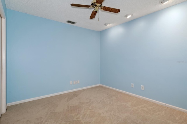 carpeted empty room with ceiling fan and a textured ceiling