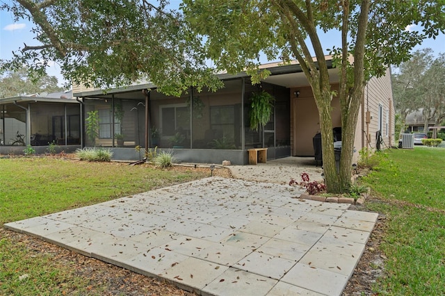 rear view of house with a sunroom, a carport, a patio area, and a lawn