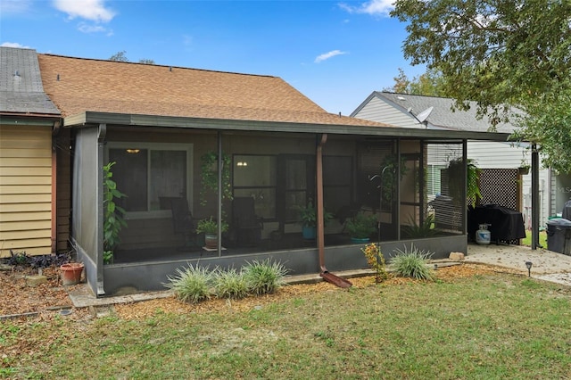 back of house featuring a sunroom and a yard