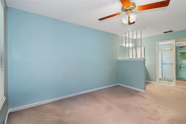 carpeted spare room with ceiling fan and a textured ceiling