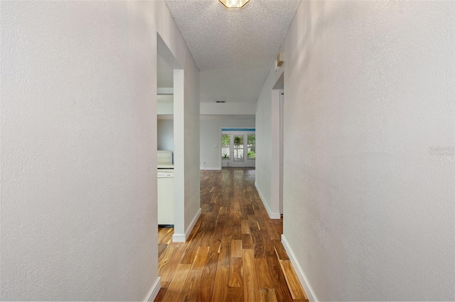 hallway with hardwood / wood-style floors and a textured ceiling