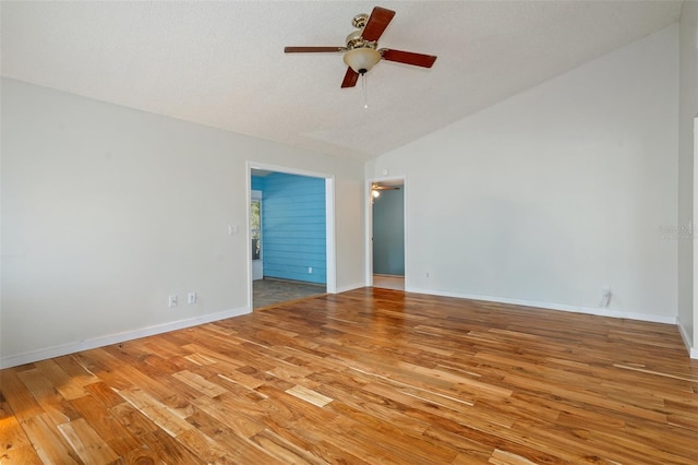 empty room with hardwood / wood-style flooring, ceiling fan, lofted ceiling, and a textured ceiling