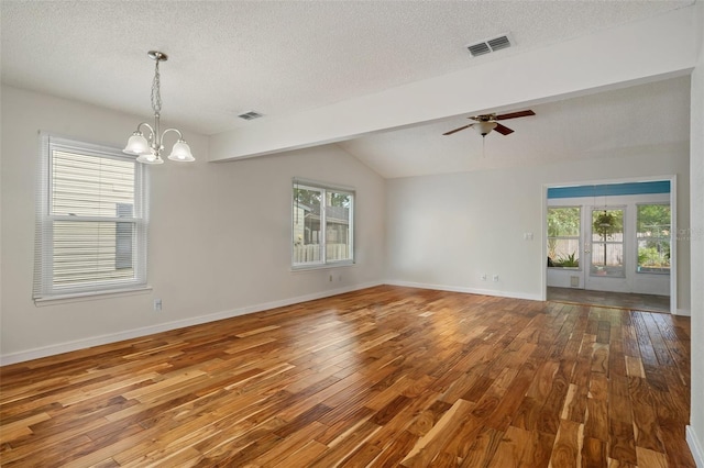 empty room featuring wood-type flooring, vaulted ceiling with beams, and a wealth of natural light