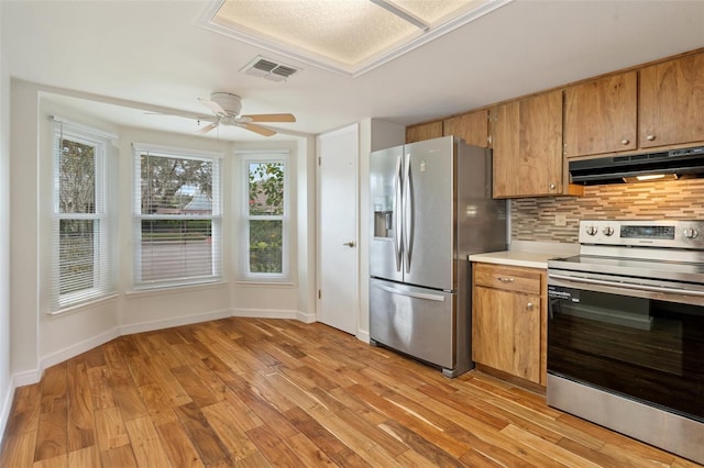 kitchen featuring tasteful backsplash, ceiling fan, stainless steel appliances, and light hardwood / wood-style floors