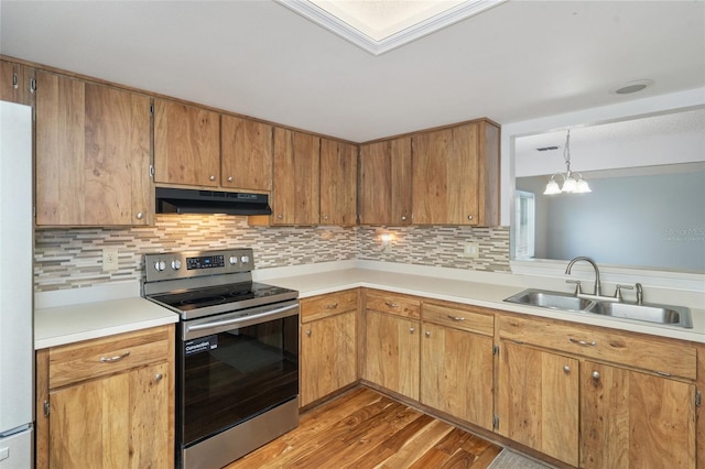 kitchen with sink, a notable chandelier, pendant lighting, stainless steel range with electric stovetop, and hardwood / wood-style flooring