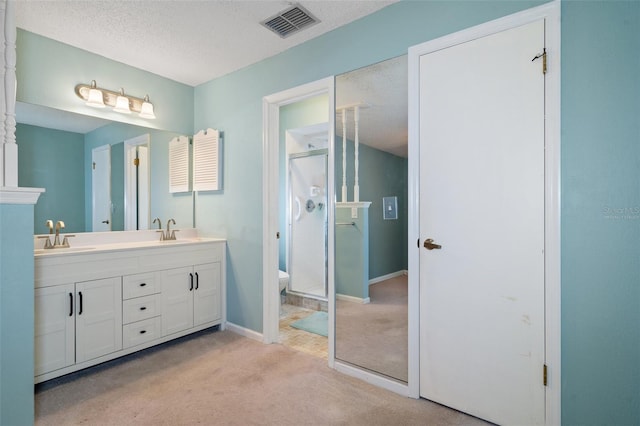 bathroom featuring vanity, a textured ceiling, and toilet