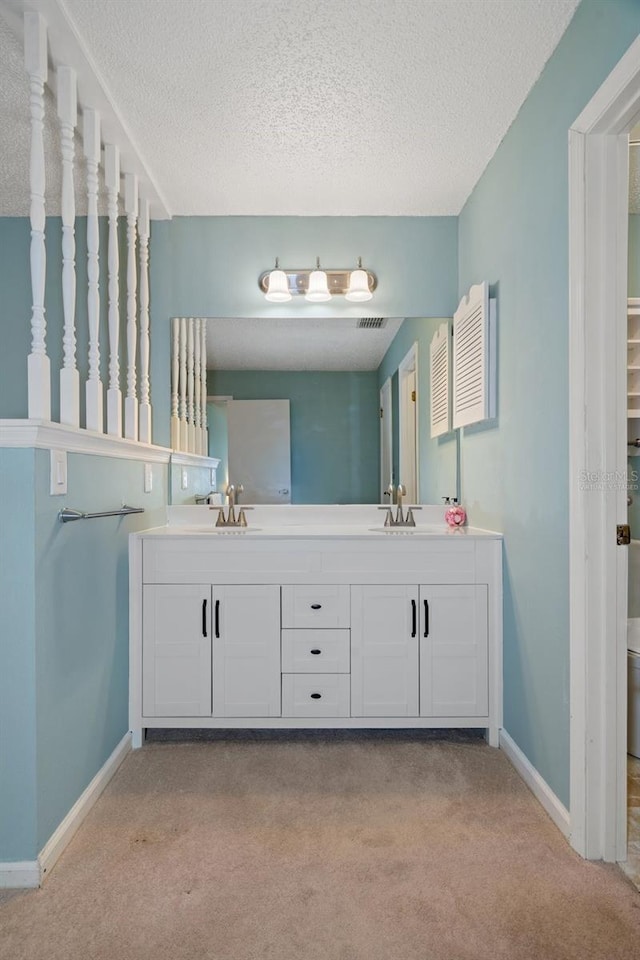 bathroom featuring vanity, a textured ceiling, and toilet