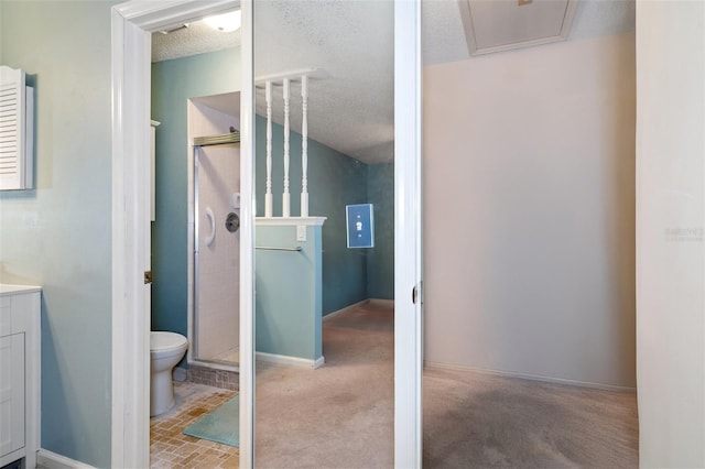 bathroom with vanity, toilet, a textured ceiling, and walk in shower