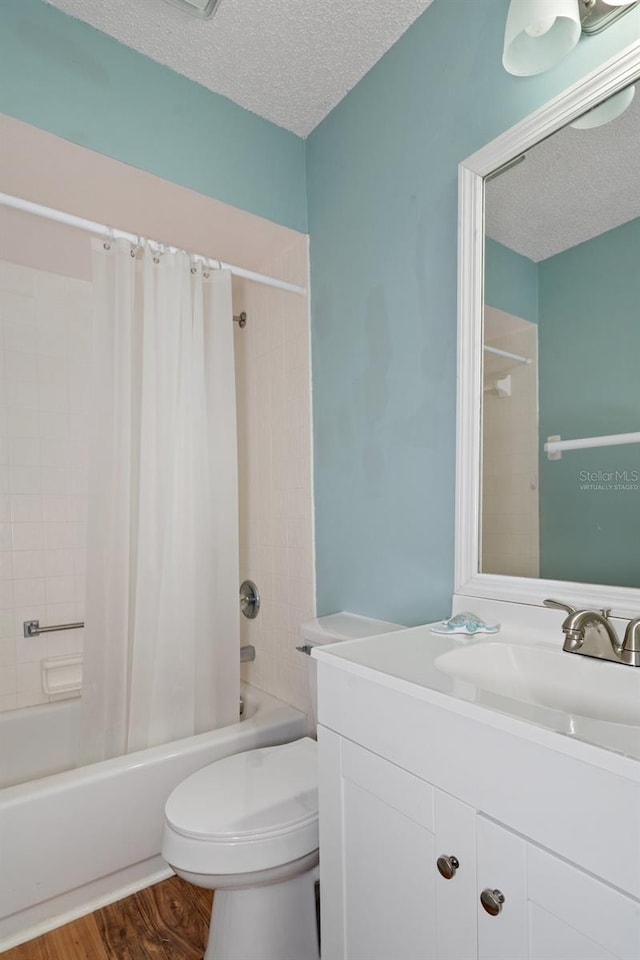 full bathroom featuring vanity, toilet, shower / bathtub combination with curtain, a textured ceiling, and wood-type flooring