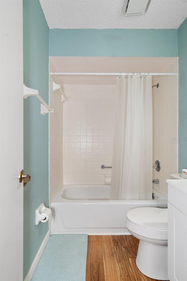 full bathroom with vanity, toilet, wood-type flooring, and a textured ceiling