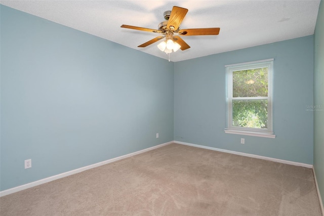 carpeted spare room featuring ceiling fan and a textured ceiling