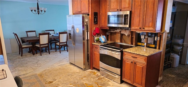 kitchen featuring an inviting chandelier, stainless steel appliances, decorative light fixtures, and light stone countertops