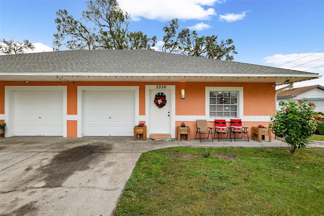 ranch-style home featuring a front lawn and a garage