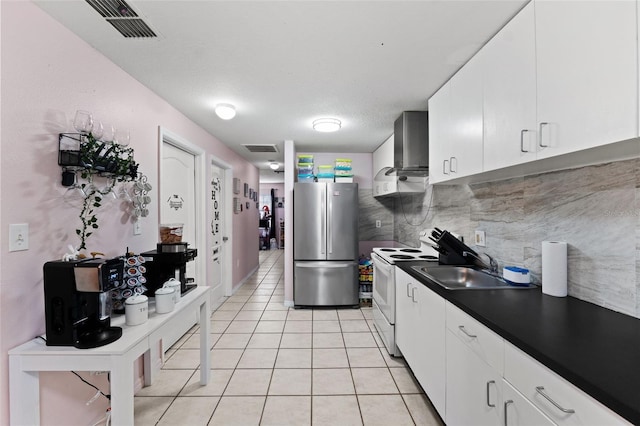 kitchen with white cabinetry, tasteful backsplash, white electric range oven, and stainless steel refrigerator