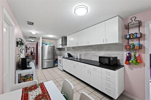 kitchen with stainless steel refrigerator, white cabinetry, backsplash, white range with electric cooktop, and wall chimney range hood