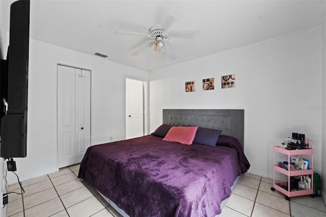 bedroom featuring light tile patterned flooring, ceiling fan, and a closet