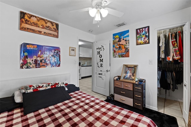 tiled bedroom with ceiling fan and a closet