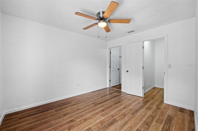 unfurnished bedroom featuring hardwood / wood-style floors and ceiling fan