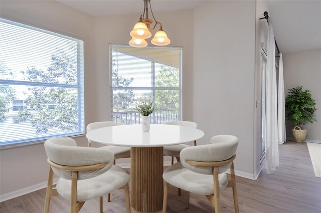 dining space featuring light hardwood / wood-style flooring and a notable chandelier