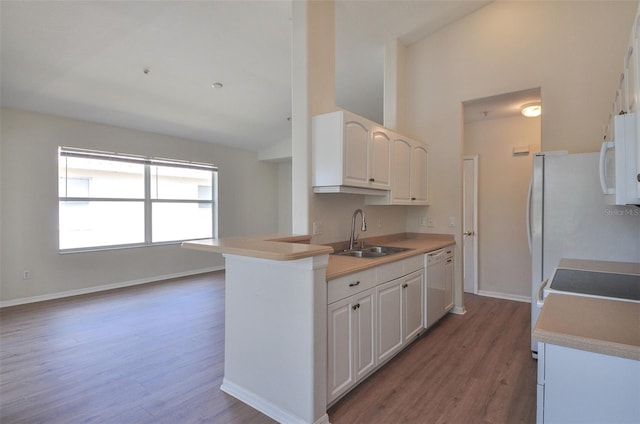 kitchen with white cabinetry, sink, dark hardwood / wood-style floors, kitchen peninsula, and white appliances