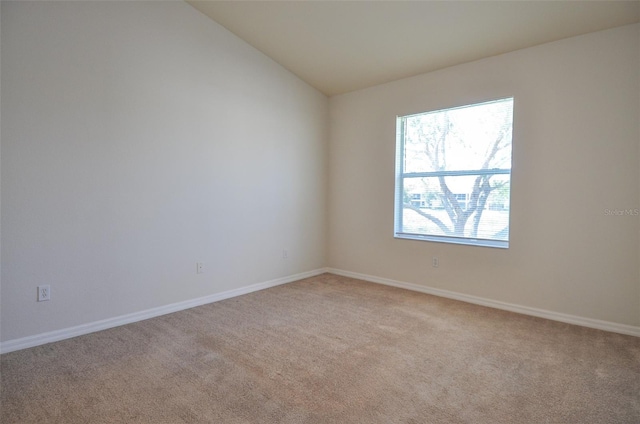 carpeted empty room with vaulted ceiling