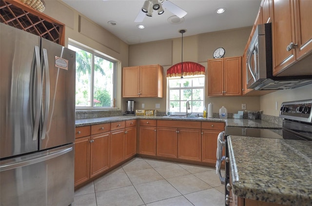 kitchen featuring sink, light tile patterned flooring, pendant lighting, ceiling fan, and stainless steel appliances