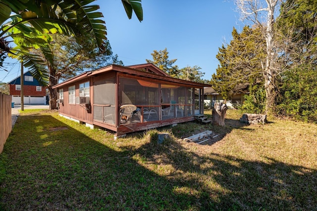 rear view of property with a sunroom and a lawn