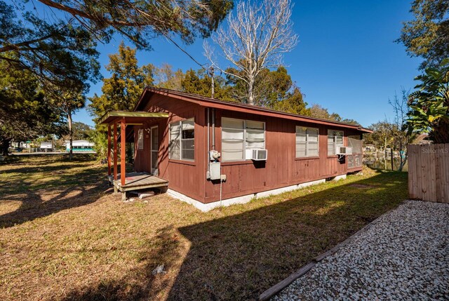 view of side of property featuring an outbuilding, a yard, and cooling unit