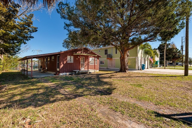 view of front of property featuring a front yard and a carport