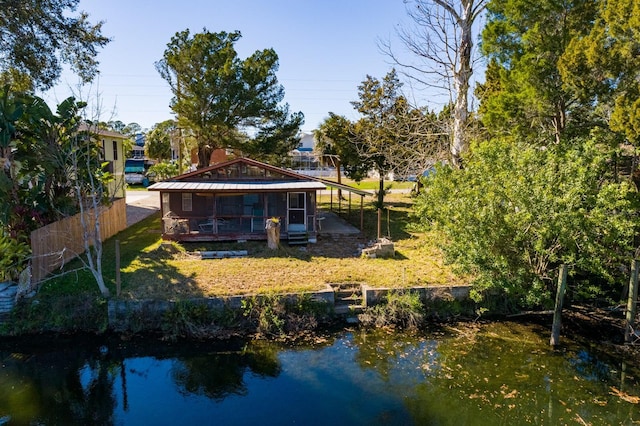 back of property featuring a lawn and a water view