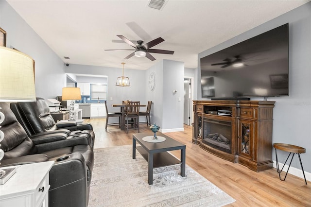 living room featuring ceiling fan and light hardwood / wood-style floors