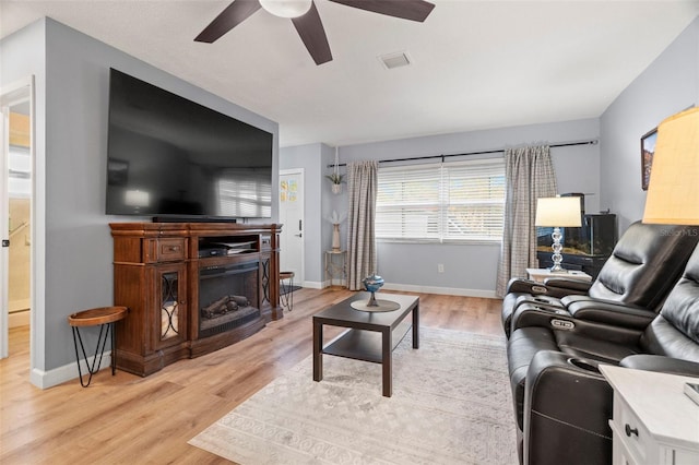 living room with ceiling fan and light hardwood / wood-style flooring