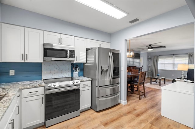 kitchen featuring white cabinetry, appliances with stainless steel finishes, ceiling fan, and light wood-type flooring