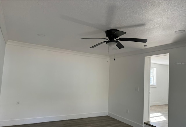 unfurnished room featuring dark hardwood / wood-style flooring, ceiling fan, a textured ceiling, and ornamental molding