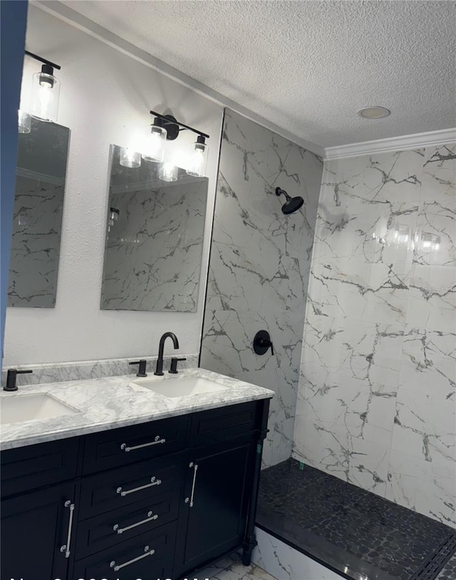 bathroom with vanity, a textured ceiling, and a tile shower