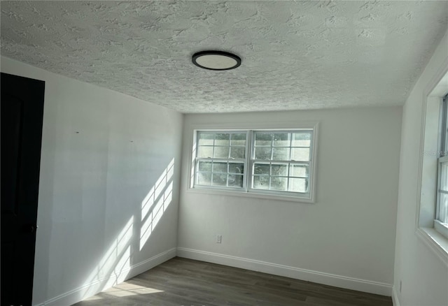 spare room featuring hardwood / wood-style floors and a textured ceiling