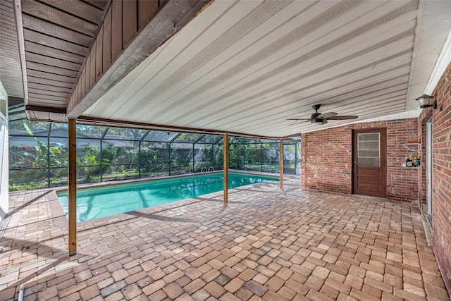 view of swimming pool featuring a patio area, ceiling fan, and glass enclosure