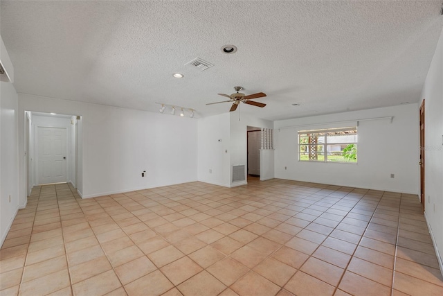 tiled spare room featuring a textured ceiling and ceiling fan